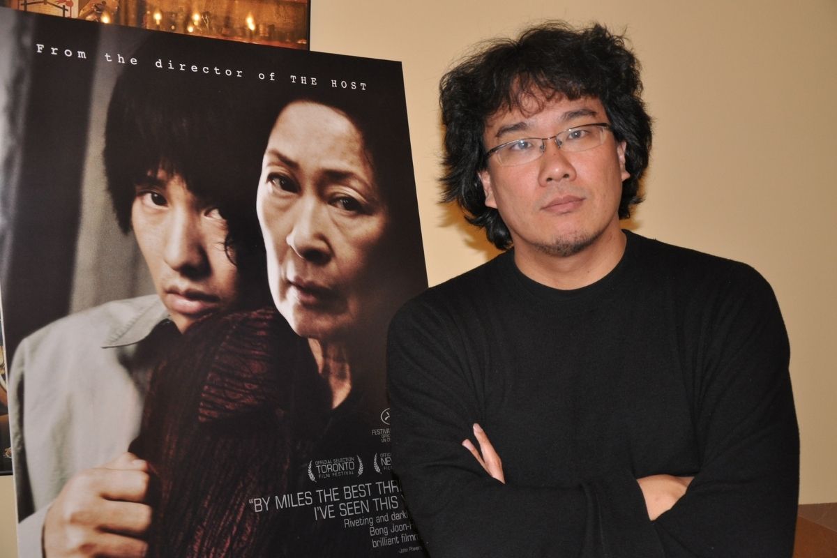 Režisér filmu spolu s plagátom k jeho prechádzajúcemu filmu Matka (Zdroj obrázku: flickr/Raffi Asdourian)
