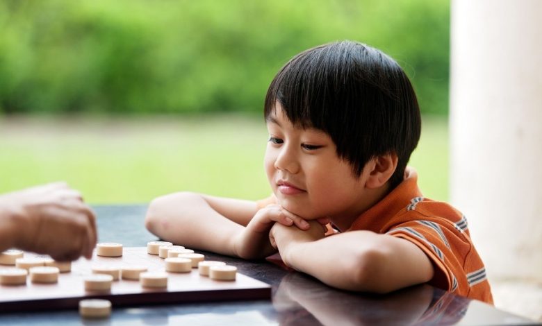 Chlapec, ktorý hrá čínsky šach (zdroj obrázku: canva.com)